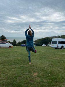 Yogahaltung auf Campingplatz am Meer