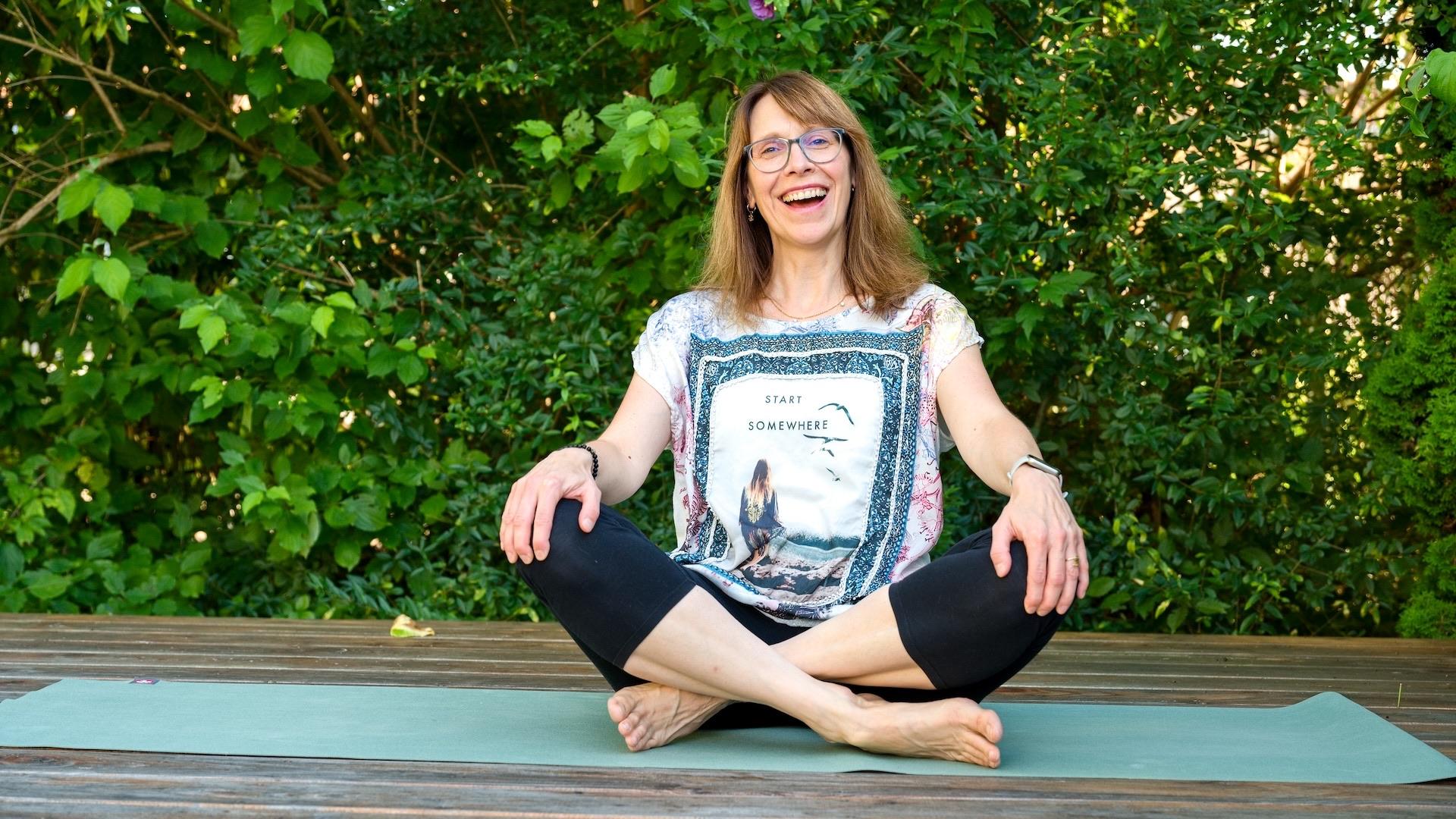 Yoga Weißenhorn: vom vollen Kopf zur inneren Klarheit Yogalehrerin Elisabeth Blässing bequem und lachend im Schneidersitz (Sukhasana)